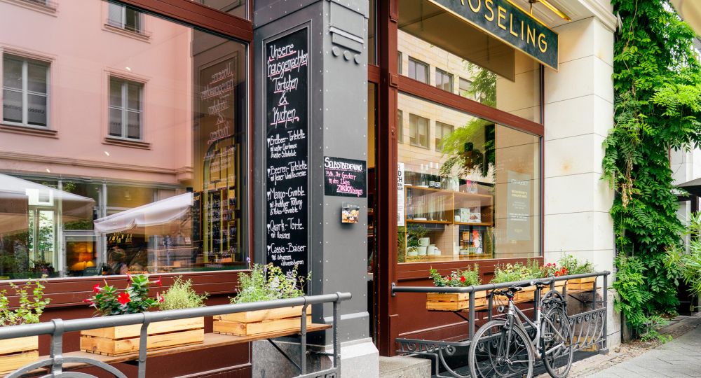 Außenansicht der Röseling-Feinkostfiliale in der Gottschedstraße 9 in Leipzig mit Eingang, Schaufenstern und Fahrrädern.